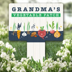 Può includere: Un cartello di legno con sfondo blu e bianco e il testo "Grandma's Vegetable Patch" in lettere verdi e bianche. Il cartello presenta un'illustrazione di vari ortaggi, tra cui carote, cipolle, patate e ravanelli.