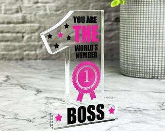 Peut inclure: Un numéro un en acrylique transparent avec du texte rose et noir. Le texte dit "You are the world's number one boss".