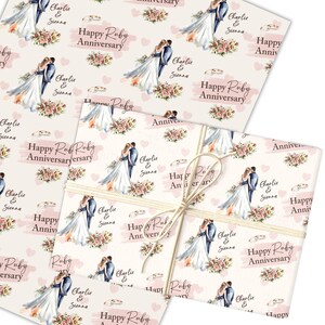 Könnte beinhalten: Geschenkpapier mit einem sich wiederholenden Muster eines Paares, Blumen und Ringen, mit dem Text "Happy Ruby Anniversary" und den Namen "Charlie & Sienna" in Rosa und Weiß. Mit Naturfaden gebunden.