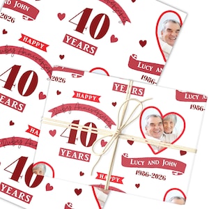 May include: White wrapping paper with a repeating pattern of red hearts, the number "40", and the words "Happy Ruby Anniversary". The paper is tied with twine and features a photo of a couple.