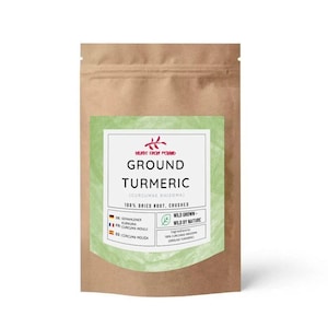 Puede incluir: Una bolsa de papel marrón de cúrcuma molida con una etiqueta verde. La etiqueta incluye el texto "GROUND TURMERIC" y "100% DRIED ROOT, CRUSHED". La bolsa está sellada en la parte superior y tiene un fondo blanco.