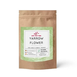 Puede incluir: Una bolsa de papel marrón con una etiqueta verde y blanca. La etiqueta dice "Yarrow Flower" e incluye texto en varios idiomas. La bolsa contiene 100% flores de milenrama secas y trituradas.