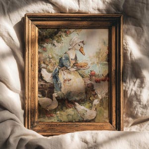 May include: A framed vintage painting shows a goose in a bonnet holding a pie, with other geese and apples. The artwork has a rustic gold frame and a soft, painterly style with muted colours, creating a pastoral scene.