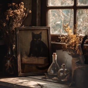 Vintage-style black cat print framed near a rustic window with dried herbs and glass bottles – dark cottagecore wall decor
