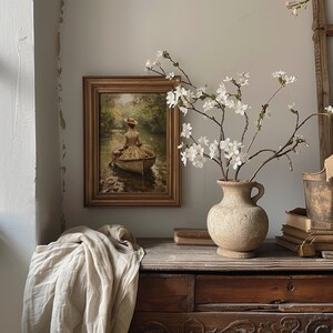 Sage green wall art of a lady in a boat, blending cottagecore and dark academia styles for a unique room decor aesthetic.