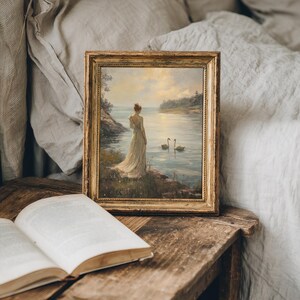 A graceful depiction of nature with a lady near a lake at sunset. This moody swan themed print enhances light academia, farmhouse, or cottagecore interiors.
