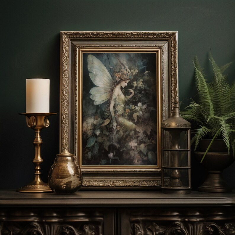May include: A framed artwork featuring a fairy with large wings amidst lush foliage. The artwork is in a gold ornate frame, displayed on a dark surface with a brass candlestick, a decorative jar, and a lantern. A fern is in a dark pot.