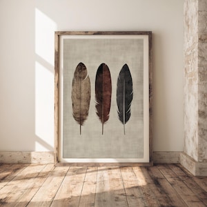 May include: A framed print featuring three stylised feathers. The feathers are brown, red and black. The background is a light grey.