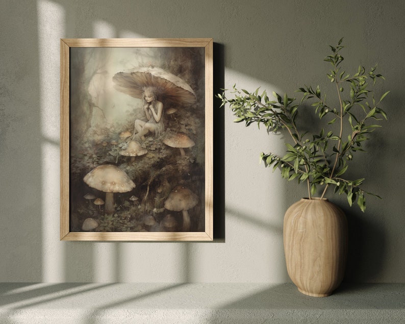 May include: A framed illustration of a fairy sitting under a mushroom in a forest setting. The fairy is wearing a white dress and has long, flowing hair. The mushrooms are brown and white and are surrounded by green foliage.