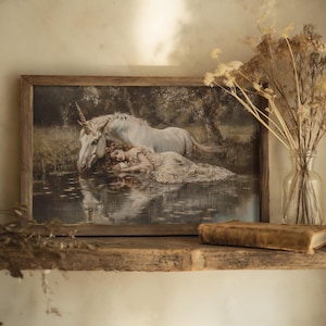A vintage fairy wall art print featuring a serene unicorn scene, suited for coquette room aesthetics.