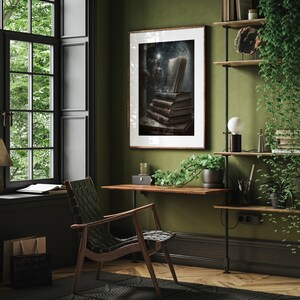 May include: A framed print of a still life featuring a stack of old books, a candle, and a window with light shining through. The print is hanging on a green wall in a home office with a desk, chair, and plants.
