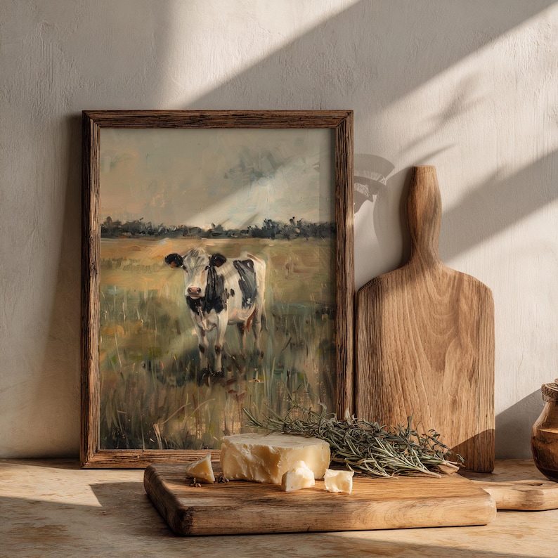 Cottagecore kitchen mockup with cow wall art in wood frame, styled with bread, ceramic bowl and herbs, warm natural light
