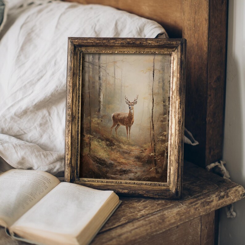 A printable deer art print in a vintage oil painting style featuring a lone buck on a misty forest trail, ideal for dark academia and cottagecore interiors with rustic wood decor.