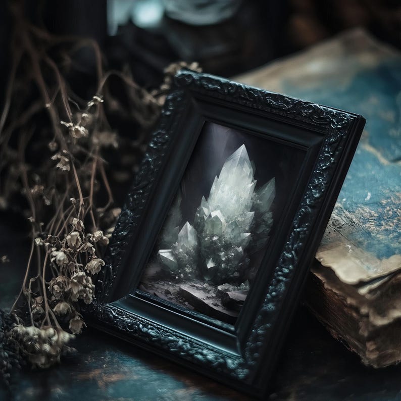 Gothic crystal artwork in ornate black frame, styled with dried herbs and mystical objects, dark academia aesthetic.