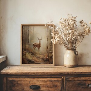 Vintage-inspired deer artwork in muted, earthy tones depicting a forest scene at dawn, available as a high-resolution digital download for dark academia or cottagecore home decor.