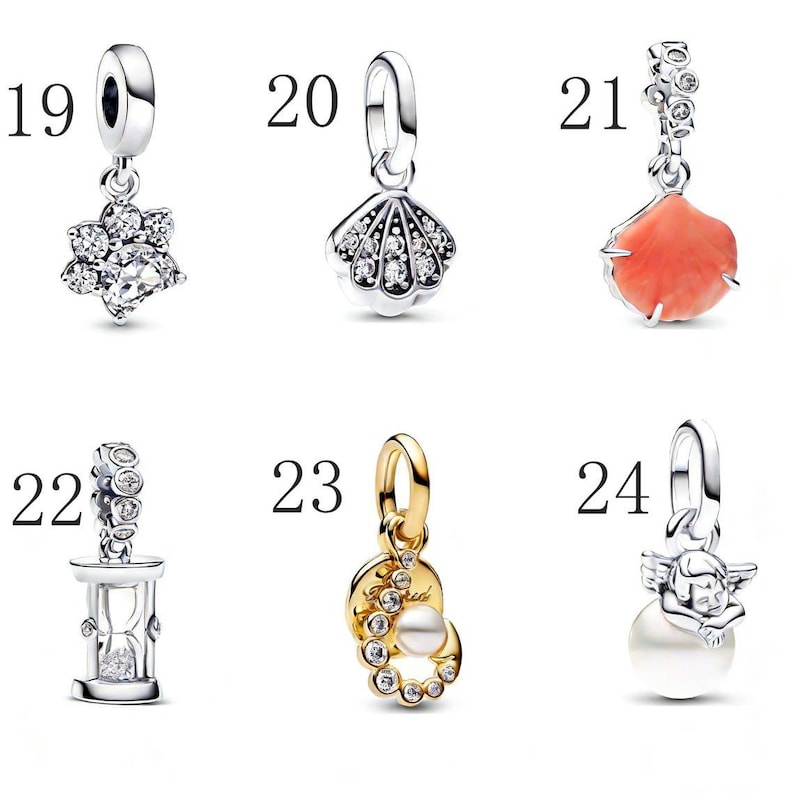 Puede incluir: Una colecci&oacute;n de abalorios plateados y dorados. Los abalorios incluyen una flor con piedras transparentes, una concha con piedras transparentes, un abalorio de color coral, un reloj de arena, un abalorio con una perla y piedras transparentes, y un abalorio con un &aacute;ngel y una perla.