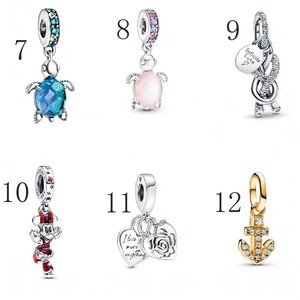 Puede incluir: Una colecci&oacute;n de abalorios de plata y oro. Los abalorios incluyen una tortuga con caparaz&oacute;n azul, una tortuga rosa, un abalorio con las palabras "Infinite Love" y un abalorio de ancla dorada.