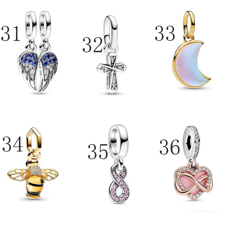 Puede incluir: Una colecci&oacute;n de abalorios plateados y dorados. Los abalorios incluyen alas de &aacute;ngel con detalles azules, una cruz, una luna creciente, una abeja, un s&iacute;mbolo de infinito y un coraz&oacute;n con un s&iacute;mbolo de infinito.