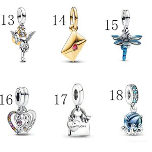 Puede incluir: Una colecci&oacute;n de abalorios de plata y oro. Los abalorios incluyen un &aacute;ngel, un sobre con un coraz&oacute;n rojo, una lib&eacute;lula, un coraz&oacute;n con detalles de arco&iacute;ris, una bolsa de la compra y un pulpo con un orbe azul.