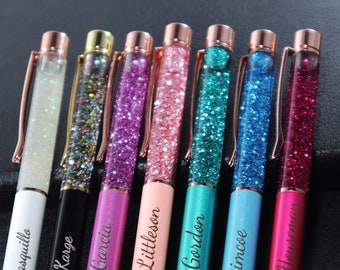 May include: Eight personalized glitter pens with rose gold accents. The pens have different colored glitter and are labeled with names:  Carrasquillo, Dakota Karge,  Vido Garcia, Liam Littleson, Michael Gordon, David Simcoe,  JJ  Husemann.