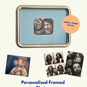 May include: A rectangular silver-toned picture frame with a light blue mat containing a black and white photo of two laughing people. A peach-colored circle features the text PRINTED + FRAMED FOR YOU. Below are additional photos and the text Personalised Framed Photos.