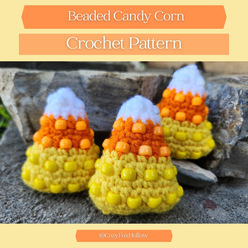 May include: Three handmade crochet candy corn decorations in yellow, orange, and white yarn. The candy corn are decorated with yellow and orange beads. The image includes the text "Beaded Candy Corn Crochet Pattern" and the Etsy shop name.