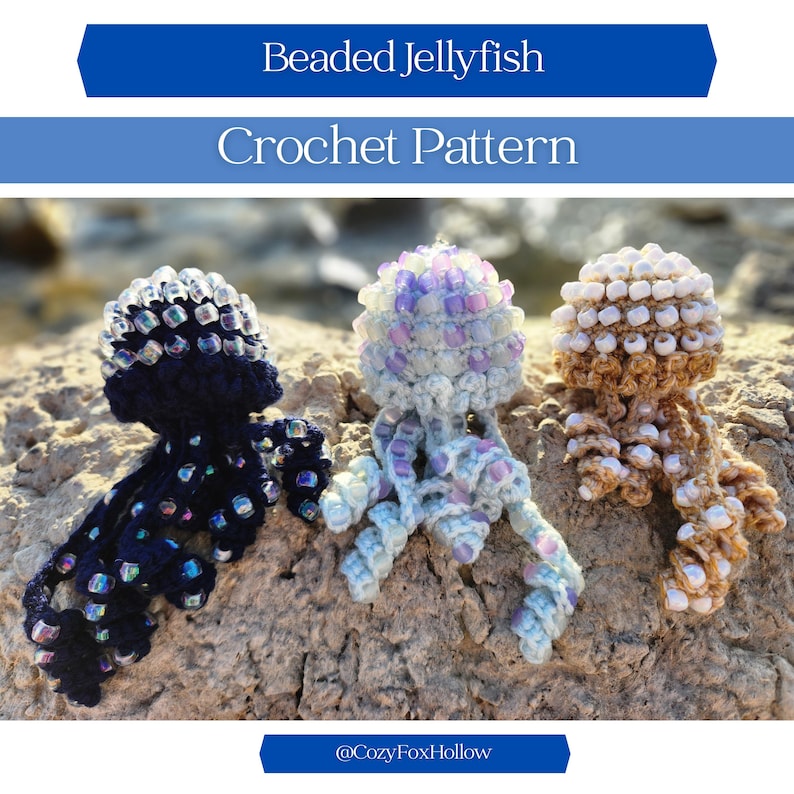 Op de afbeelding: Drie gehaakte kwallen met kralen in marineblauw, lichtblauw en bruin. De kwallen hebben met kralen bezette kappen en bungelende tentakels. De afbeelding bevat de tekst "Beaded Jellyfish Crochet Pattern" en de Etsy shopnaam "@CozyFoxHollow".