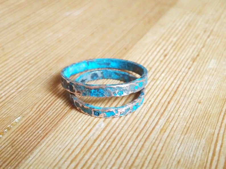 May include: Two copper rings with a turquoise patina finish. The rings are stacked on top of each other.