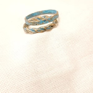 May include: Two gold rings with a blue and gold speckled finish. The rings are stacked on top of each other.