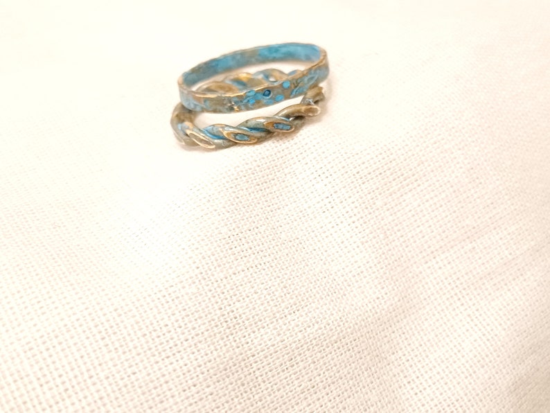 May include: Two gold rings with a blue and gold speckled finish. The rings are stacked on top of each other.