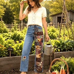 May include: A cream-colored short-sleeve blouse with a V-neckline and button front, paired with blue denim jeans featuring a patchwork panel of floral and plaid fabric on the right leg, a small patch on the left leg, a straw hat, and tan clogs.