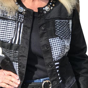 May include: A black denim jacket with a patchwork design featuring black and white gingham, stripes, and polka dots. The jacket has a button closure and a collar.