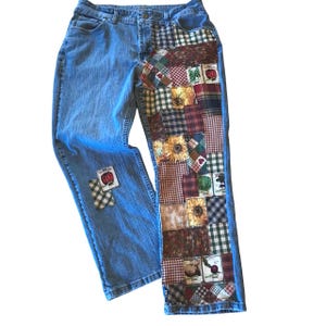 May include: Light blue denim jeans with patchwork detailing. The patchwork features various fabric patterns, including gingham, floral, and plaid, with images of vegetables. The jeans have a classic five-pocket design.