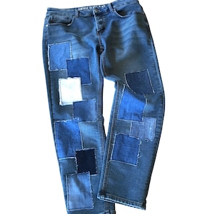 May include: Blue denim jeans with multiple patches of different shades of blue denim sewn on the front of the legs.