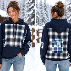 May include: A navy blue hooded sweatshirt featuring a large front and back panel of navy, white, and light blue plaid fabric. The hoodie includes a front kangaroo pocket, plaid elbow patches, and a small rectangular label on the back pocket.