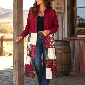 May include: A long-sleeved, button-down duster coat in deep red, featuring a patchwork lower section with cream, plaid, and floral fabric panels. The coat is worn over a black top and blue denim jeans, paired with a brown cowboy hat and a silver necklace.