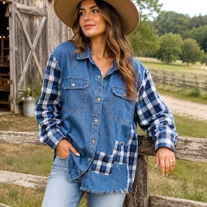 May include: A long-sleeve button-down shirt featuring a blue denim bodice with two chest pockets and contrasting blue and white plaid flannel sleeves and side panels. The shirt has a frayed hemline and is paired with light blue distressed denim jeans.