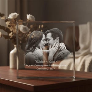 May include: A clear glass photo block featuring a black and white image of a couple embracing. The block includes the names "Michael + Sarah" and the date "September 3, 2014", along with a quote about home.