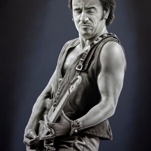Puede incluir: Una fotografía en blanco y negro de un hombre tocando una guitarra eléctrica. Lleva un chaleco sin mangas y tiene una expresión seria en su rostro.