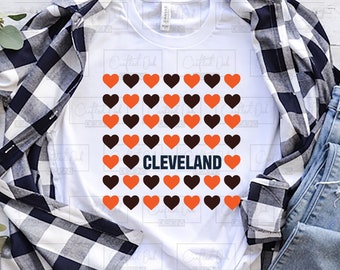 Puede incluir: Una camiseta blanca con un diseño de corazones naranjas y marrones con la palabra "CLEVELAND" en el centro. El diseño está en una camiseta blanca con una camisa a cuadros y unos vaqueros azules en el fondo. El texto "LOVE CLEVELAND BROWNS" está en la parte superior de la imagen y el texto "INCLUDES SVG PNG" está en el lado derecho de la imagen.