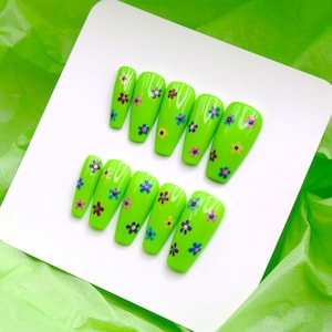 Könnte beinhalten: Set mit zehn limegrünen Press-on-Nägeln mit bunten Blumendesigns.