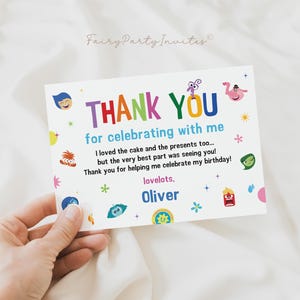 May include: A white thank you card with colorful text and cartoon characters. The card reads "THANK YOU for celebrating with me" and includes a personal message and the name "Oliver". The card is held by a hand.