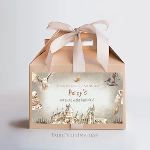 Puede incluir: Una caja de regalo marrón con una cinta blanca y una pegatina que dice "Gracias por venir al mágico octavo cumpleaños de Percy!" La pegatina presenta una ilustración de acuarela del castillo de Hogwarts, un búho y un sombrero de mago.