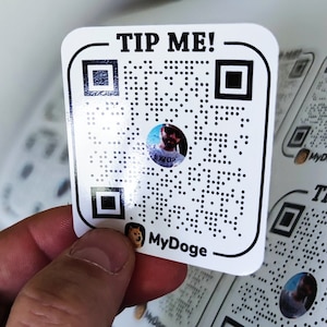 May include: White square sticker with a black and white QR code, the text "TIP ME!" and the text "MyDoge" with a small image of a dog.