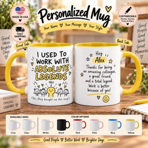 May include: Two white ceramic mugs with yellow handles and interiors. The front mug features the text 'I USED TO WORK WITH ABSOLUTE LEGENDS' and a cartoon illustration. The back mug displays the text 'Hey Alex Thanks for being an amazing colleague'.