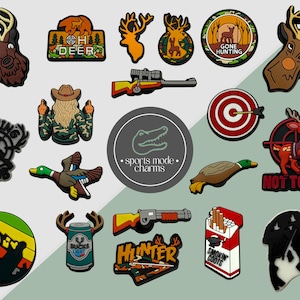 Può includere: Una collezione di ciondoli a tema caccia in varie forme e colori. I disegni includono teste di cervo, fucili, un bersaglio, un'anatra e il testo che dice "OH DEER", "GONE HUNTING", "HUNTING CLUB", "NOT TODAY", "HUNTER" e "SMOKIN COOTS".