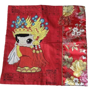 May include: Red cross-stitch embroidery kit featuring a cartoon character wearing a yellow crown and red clothing. The kit includes a printed fabric with a grid pattern and a chart with instructions. The text on the chart reads "S8842-JR (113WX 130H) 濃滑精准100%"