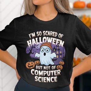 Op de afbeelding: Zwart T-shirt met een witte geest die een bril en een muts draagt. De tekst op het shirt luidt "Ik ben zo bang voor Halloween, maar niet voor informatica".