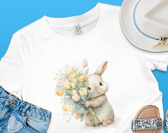 Puede incluir: Una camiseta blanca con una ilustración de acuarela de un conejito sosteniendo un ramo de tulipanes amarillos y rosas.