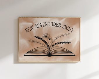 May include: A framed print with the words "NEW ADVENTURES AWAIT" in black script above an open book illustration. The book has floral accents. The background is a soft, watercolor-style wash of peach and cream.